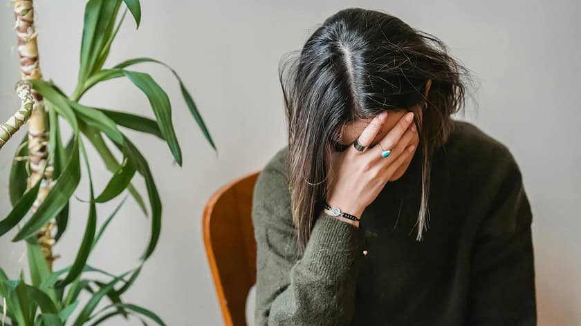 worried young woman covering face with hand